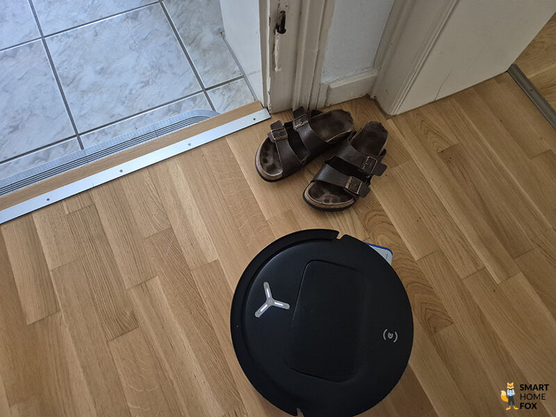 Die Kamera- und Sensorik des ECOVACS DEEBOT T80 OMNI erkennt ein paar Schuhe als Hindernis.